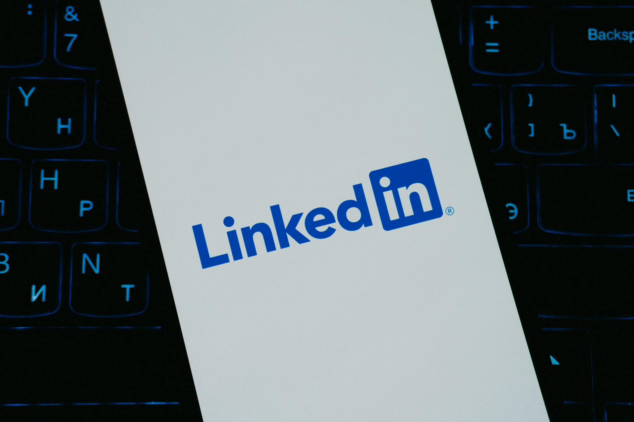 Close-up of LinkedIn logo on smartphone screen, with keyboard background.